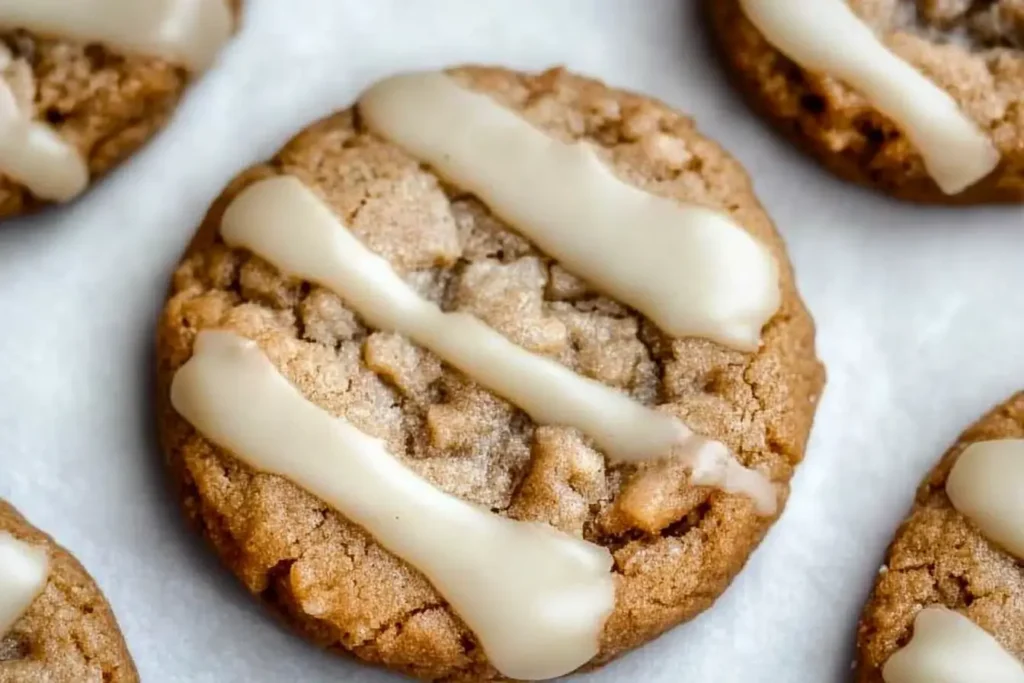 Close-up of multiple maple cookies with a thick maple glaze, highlighting their crumbly texture and sweet drizzle.